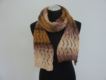 Gestrickter Schal mit Ajourmuster und sanftem Farbverlauf an einer schwarzen Schaufensterpuppe