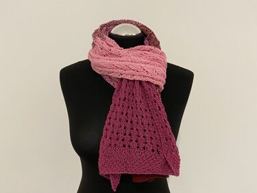 Gestrickter Schal mit Farbverlauf von Hellrosa zu Dunkelmagenta und Lochmuster auf schwarzer Schneiderpuppe