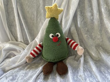 Gehäkelter grüner Amigurumi-Weihnachtsbaum mit gelbem Stern und gestreiften Armen
