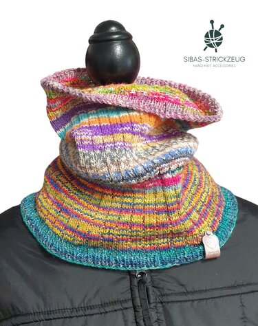 Bunter gestrickter Loopschal auf schwarzer Schaufensterpuppe mit gerollter Kante