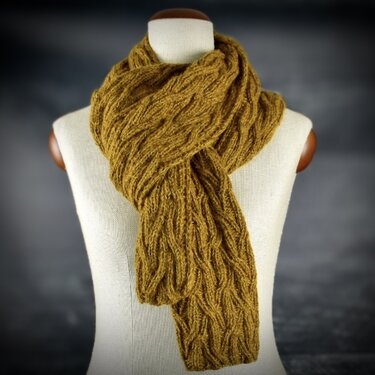 Senfgelber Strickschal mit Wellenmuster auf einer Schneiderpuppe