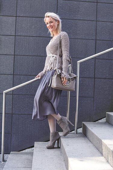 Gehäkelte Wickeljacke mit Spitzenborte.