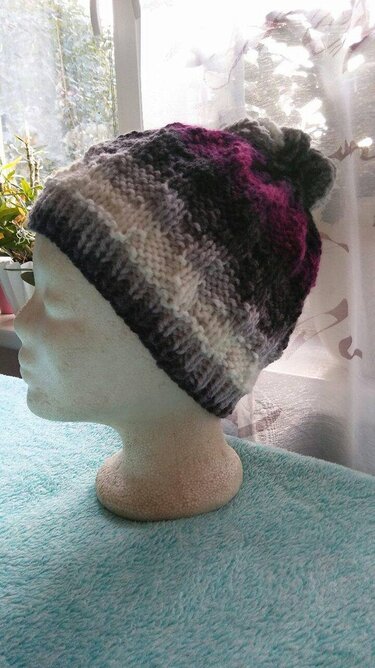 Mehrfarbige gestrickte Damenmütze auf Schaufensterkopf in Grau, Creme und Magenta