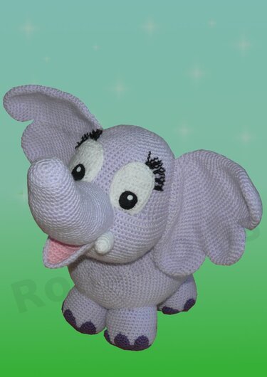 Lavendelfarbener gehäkelter Amigurumi Elefant mit großen Ohren vor grünem Hintergrund