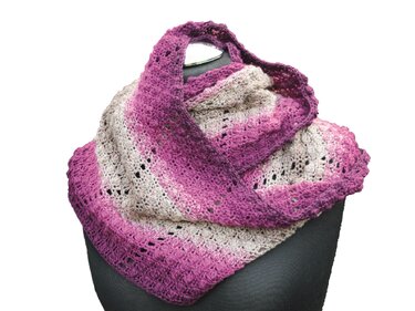 Gehäkelter Loop in Rosa und Beige mit offenem Lochmuster auf Büste drapiert