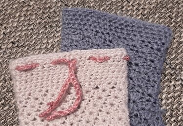 Rechteckige Häkelproben, vorne rosa mit Kordel, hinten blau