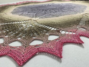 Close-up of crochet stitches and scalloped edge on a round gradient doily
