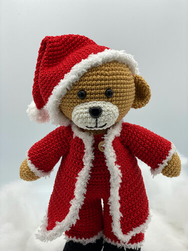 Amigurumi-Bär mit weihnachtlicher Puppenkleidung: roter Mantel und Zipfelmütze