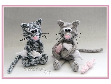 Zwei gehäkelte Amigurumi-Katzen (grau gesprenkelt und hellgrau) mit kleinen gehäkelten Mäusen
