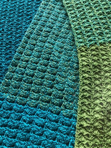 Detail zweier Häkelmuster nebeneinander: dichter Sternstich rechts und ausgeprägter Muschelstich links in Türkis‑Grün
