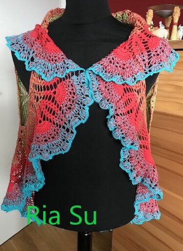 Ärmellose gehäkelte Damenweste in Koralle und Türkis mit Rüschenkante auf Schneiderbüste