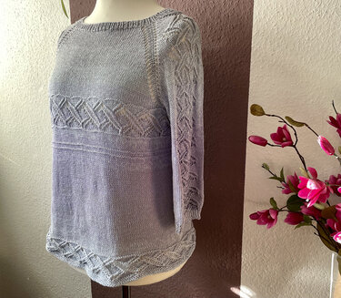 Pastellblauer Damenpullover mit Lochmuster an Passe, Ärmeln und Saum auf Schneiderpuppe