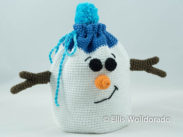 Weißes gehäkeltes Schneemann-Säckchen mit blauer Bommelmütze, orangener Nase und braunen Armen