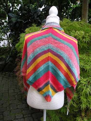 Gestricktes Dreieckstuch mit bunten V‑förmigen Streifen auf einer Schneiderpuppe.