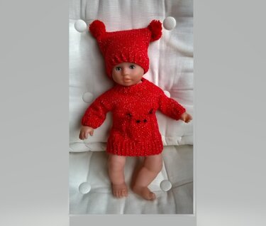 Babypuppe in rotem gestricktem Pulloverkleid und Zipfelmütze mit zwei Bommeln