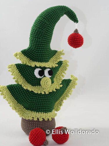 Gehäkelte grüne Weihnachtsfigur mit roter Kugel und großen Augen