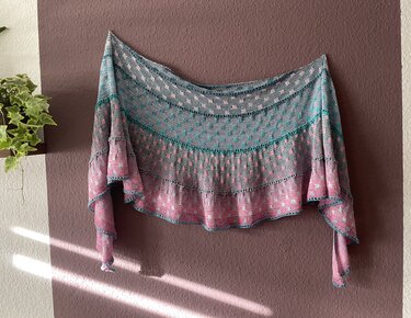 Halbrundtuch mit Farbverlauf in Grau, Türkis und Rosa, an einer Wand drapiert