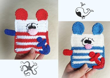 Zwei gehäkelte, quadratische Babyspielzeuge in blau-weiß und rot-weiß mit Öhrchen, bestickten Augen und aufgenähten Anker-Applikationen.