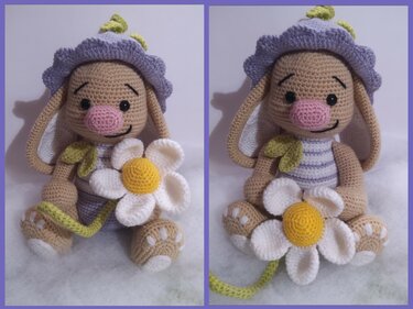 Gehäkeltes Häschen mit lila Blumenhut und Gänseblümchen auf hellem, weichem Untergrund