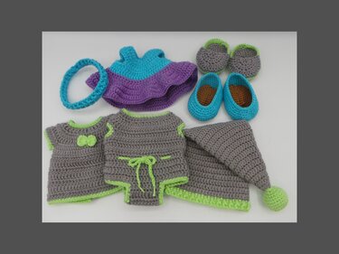 Gehäkeltes Amigurumi-Puppen-Set: Kleid, Oberteil, Strampler, Zipfelmütze, zwei Paar Schuhe und Stirnband in Grau, Türkis, Lila und Limette.