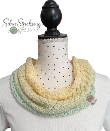 Gestrickter Loop-Schal in Pastellfarben Mint und Gelb auf Schaufensterbüste