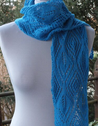 Blauer Strickschal mit Rauten‑Lochmuster auf weißer Schaufensterpuppe