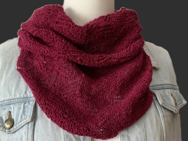 Bordeauxfarbenes gestricktes Dreieckstuch mit offenem Maschenbild auf Schaufensterpuppe über Jeansjacke