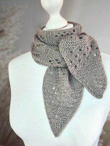 Taupefarbener, dreieckiger Strickschal mit Lochmuster auf einer Schaufensterpuppe