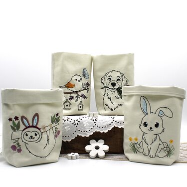 Vier ITH‑Stoffhüllen mit gestickten Tiermotiven, geeignet als Hüllen für LED‑Tischlichter.