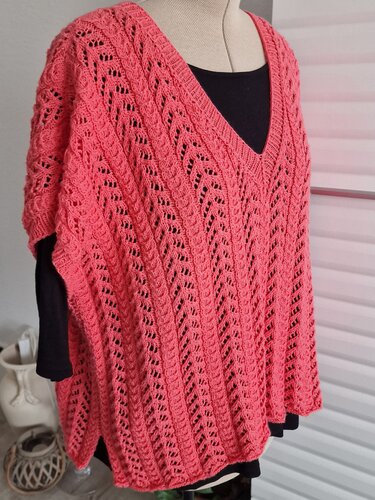Korallfarbener, gestrickter Damen‑Poncho mit V‑Ausschnitt und Lochmuster auf Anprobe‑Figur