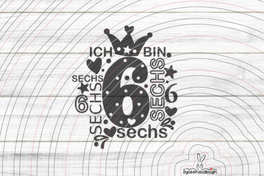 Schwarze Vektorgrafik mit dem Schriftzug 'Ich bin sechs', großer Ziffer 6, Krone, Herzen und Sternen vor hellem Holz-Hintergrund.