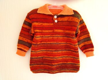 Handgestrickter Kinderpullover, gestreift in Rot, Orange und Braun, mit Kragen und zwei weißen Knöpfen