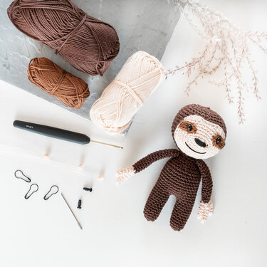 Gehäkeltes Faultier-Amigurumi mit Garn und Häkelnadel