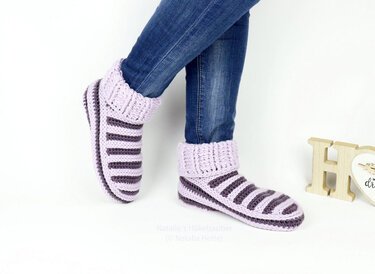 Legs in jeans wearing lavender and gray striped crocheted ankle slippers with folded ribbed cuffs