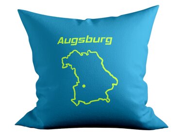 Türkisfarbenes Kissen mit neongrüner Plottgrafik: Schriftzug 'Augsburg', stilisierter Bayern-Umriss und Punktmarkierung