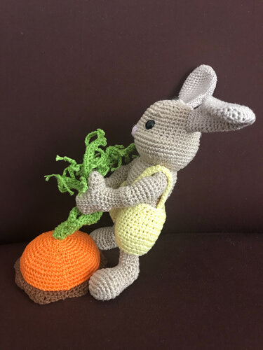 Gehäkelter Amigurumi‑Hase im gelben Strampler mit gehäkelter Möhre