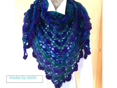 Gehäkeltes Dreieckstuch in Blau, Lila und Türkis mit Muschelmuster, an einer Schneiderpuppe drapiert.