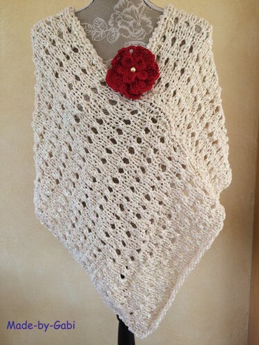 Offwhite gestrickter Poncho mit V‑Ausschnitt, Lochmuster und roter Häkelblüte mit Perlen