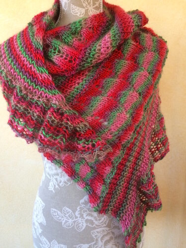 Mehrfarbiges gestricktes Dreieckstuch in Rot-, Pink- und Grüntönen mit diagonalen Streifen und feinem Lochmuster auf einer Schneiderpuppe drapiert.