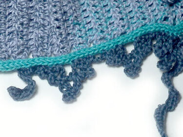 Detail der gehäkelten Schal-Kante mit Schlaufen, Picot-Effekt und türkisfarbener Einfassung