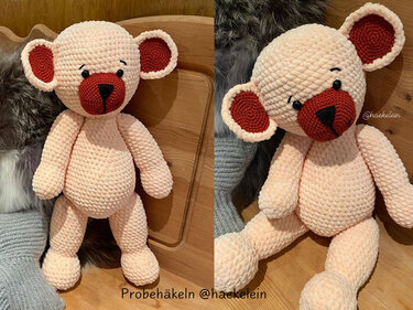 Gehäkelter rosa Amigurumi-Teddy mit roter Schnauze und schwarzen Augen