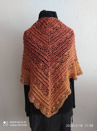 Gehäkeltes Dreieckstuch mit Lochmuster und Zackenrand, Farbverlauf in rost- und senftönen, drapiert auf schwarzem Mannequin