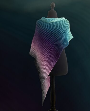 Crocheted ombre triangle shawl in teal, purple, and grey on a mannequin showing ribbed diagonal texture.