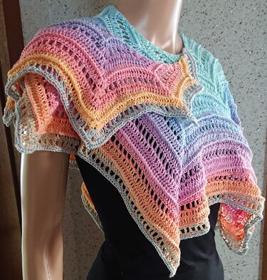 Gehäkeltes Tuch in Pastellfarben mit filigranem Lochmuster auf Schaufensterpuppe