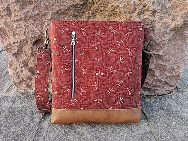 Rote Crossbody-Tasche mit senkrechtem Außenfach und hellbraunem Boden