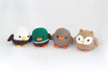 Vier verschiedene gehäkelte Vögel im Amigurumi-Stil: adlerähnlich, Ente, brauner Vogel und Eule.