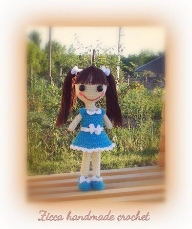 Crocheted amigurumi doll showing stitch texture and pigtails with bows