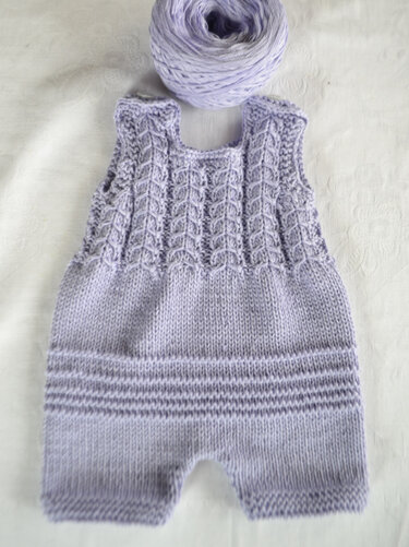 Gestrickter fliederfarbener Baby-Strampler mit Zopfmuster