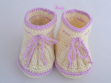 gelb-rosa gestrickte Baby-Booties mit Bindeband