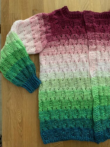 Nahaufnahme gehäkelte Damenjacke mit Reliefstichen, gerippten Bündchen und Farbverlauf von Dunkelrot zu Blau